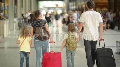 幸福的家庭和小女孩和男孩一起去火车站，爸爸妈妈和孩子们一起穿过机场